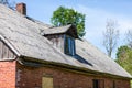 Old wooden roof with small window and chimney in rural Latvia, Europe. Royalty Free Stock Photo