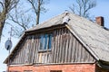 Old wooden roof with small window and chimney in rural Latvia, Europe. Royalty Free Stock Photo