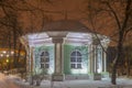 Old wooden round pavilion in winter park at night. Royalty Free Stock Photo