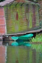 Old wooden rowing blue boat floating on pond at rusty pier pavilion background Royalty Free Stock Photo