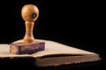 Old wooden rubber stamp on the book. Office accessories used in the office Royalty Free Stock Photo