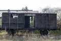 Old wooden ruined boxcar standsing on the rails on the background of blue sky Royalty Free Stock Photo