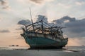 The old wooden ruined fishing boat set aground on the beach at Sunset time Royalty Free Stock Photo