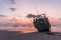 The old wooden ruined fishing boats set aground on the beach at Sunset time Royalty Free Stock Photo