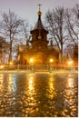 Old wooden russian church. Streets after rain, wet asphalt Royalty Free Stock Photo