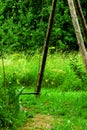 Old wooden rustic garden iron chain hanging swing on green grass background