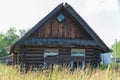 Old wooden rustic ruined abandoned house with boarded up windows on a bright summer sunny day. Close-up. Royalty Free Stock Photo