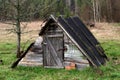 Old wooden rustic shed in the middle of a field by the forest. Royalty Free Stock Photo