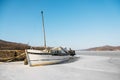 Old wooden sailboat moored at pier and frozen in sea ice against backdrop of amazing sea winter landscape. impossible to engage in