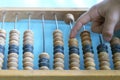 Old wooden scores. Hand on abacus . counter. retro calculator Royalty Free Stock Photo