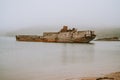 Old wooden shipwreck boat, foggy morning lonely shore. Royalty Free Stock Photo