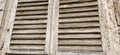 Old wooden shutters on the window. Antique wooden architecture. Dry wood with rustling discolored paint. Husk and dust. Natural