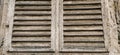 Old wooden shutters on the window. Antique wooden architecture. Dry wood with rustling discolored paint. Husk and dust. Natural