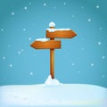 Old wooden signpost covered with snow on the snowy ground. Two arrow shaped planks pointing in different directions.