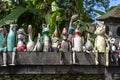 Old wooden souvenirs toys on the stone fence near the doll shop in Ubud, Bali island, Indonesia. Closeup