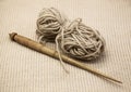 Old wooden spindle with a ball of wool thread for the manufacture of woolen threads on a tissue background