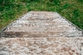 Old wooden stairs going down on a background of green grass. Top view. Copy, empty space for text Royalty Free Stock Photo