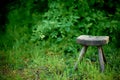 Old wooden stool is situated in a field of lush green grass. Royalty Free Stock Photo