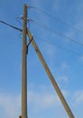 Old wooden support of power transmission lines 0.4 kV with wires and insulators on a blue sky background, vertical image Royalty Free Stock Photo