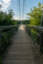 An old wooden suspension bridge over the river in the park. Wooden background for text. Autumn landscape Royalty Free Stock Photo