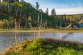 Old wooden suspension bridge over the river in spring. Beautiful landscape Royalty Free Stock Photo