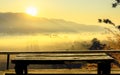 Old wooden table at the coffee shop blurred background  The sun's rays through at the top of the hill and the moving fog Royalty Free Stock Photo