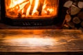 Old wooden table and fireplace with warm fire at the background Royalty Free Stock Photo