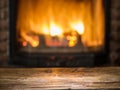 Old wooden table and fireplace with warm fire. Royalty Free Stock Photo