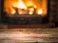 Old wooden table and fireplace with warm fire.