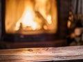 Old wooden table and fireplace with warm fire. Royalty Free Stock Photo