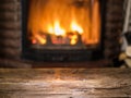 Old wooden table and fireplace with warm fire. Royalty Free Stock Photo