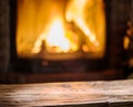 Old wooden table and fireplace with warm fire.