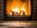 Old wooden table and fireplace with warm fire.