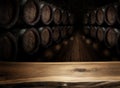 Old wooden table top and oak wine barrels at the background Royalty Free Stock Photo