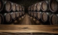 Old wooden table top and oak wine barrels at the background Royalty Free Stock Photo