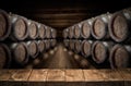 Old wooden table top and oak wine barrels at the background Royalty Free Stock Photo