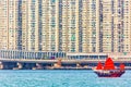 Old wooden tourist junk ferry boat in Victoria Harbor against famous Hong Kong island view with skyscrapers Royalty Free Stock Photo