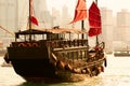 Old wooden tourist junk ferry boat in Victoria Harbor against famous Hong Kong island view with skyscrapers Royalty Free Stock Photo