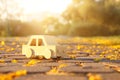 Old wooden toy car on the road outdoors in the park at sunset. nostalgia and simplicity concept. Royalty Free Stock Photo