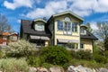 Old wooden two storey cottage villa in countryside. Beautiful yellow green colored village house with black roof and landscape Royalty Free Stock Photo