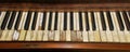 Old wooden upright grand piano black and white keys with detailed real ivory inlays with some missing on late 1800s instrument, Royalty Free Stock Photo