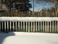 Old wooden village fence covered with snow. Snowy winter in the Royalty Free Stock Photo