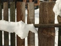 Old wooden village fence covered with snow. Snowy winter in the Royalty Free Stock Photo