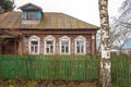 An old wooden village house behind a fence . Royalty Free Stock Photo