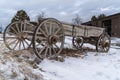 An old wooden wagon on a rocky terrain covered with snow in winter