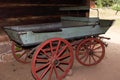 An old wooden wagon for transporting people or goods with large red wheels Royalty Free Stock Photo