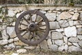 Old wooden wagon wheel hanging against a stone wall Royalty Free Stock Photo