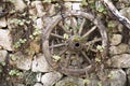 Old wooden wagon wheel hanging against a stone wall Royalty Free Stock Photo