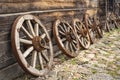 Old wooden wagon wheels leaning on a log cabin Royalty Free Stock Photo