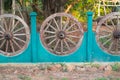 Old wooden wagon wheels into a wall in Thailand